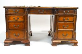 A mahogany partner's desk, the shaped top set a green leather skiver, over three drawers,