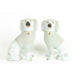 A pair of Staffordshire models of poodles, each with moulded numeral to base,