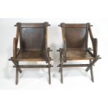 A pair of oak Glastonbury chairs, with panelled backs and seat,