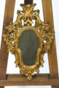 A carved giltwood rococo style mirror framed,