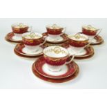A Mintons dark pink ground part tea service with gilt borders of leafy tendrils,