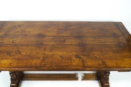 An oak refectory table with triple plank top on two turned baluster supports to either end