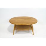 An Ercol elm and beech oval coffee table, with turned spindle lower shelf,