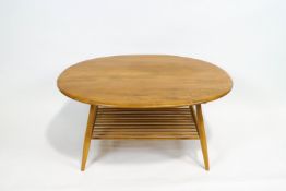 An Ercol elm and beech oval coffee table, with turned spindle lower shelf,