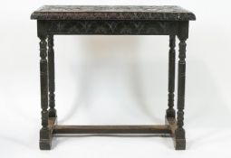 A Victorian carved oak table with deep carved frieze on turned legs, linked by H stretchers,