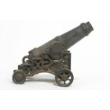 A cast iron model of a siege cannon, on a fancy carriage, decorated with a fan motif,