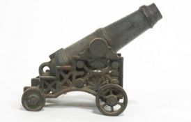 A cast iron model of a siege cannon, on a fancy carriage, decorated with a fan motif,