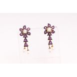 A yellow and white metal pair of drop stud earrings, each set with amethysts and seed pearls.