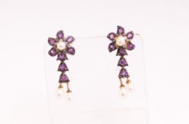 A yellow and white metal pair of drop stud earrings, each set with amethysts and seed pearls.