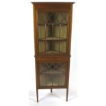 An Edwardian mahogany corner cabinet with boxwood and ebony stringing to the two glazed doors,