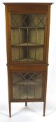 An Edwardian mahogany corner cabinet with boxwood and ebony stringing to the two glazed doors,