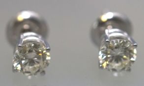 A white metal pair of single stone studs.