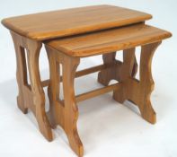 An Ercol elm wood nest of two rectangular tables,