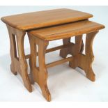 An Ercol elm wood nest of two rectangular tables,