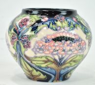 A small Moorcroft ginger jar style vase, with stylised hydrangea decoration on a blue ground,