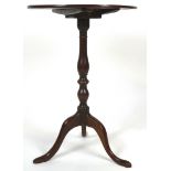 A George III mahogany tilt-top tripod table, the circular top above baluster stem,