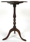 A George III mahogany tilt-top tripod table, the circular top above baluster stem,