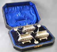 A cased six piece cruet set, comprising a silver covered mustard and two salts,