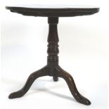 A Provincial mahogany and oak tripod tea table, the tilt-top circular table above a baluster stem,