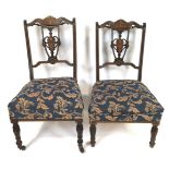 A pair of Edwardian mahogany salon chairs with urn splat backs inlaid with anthemion