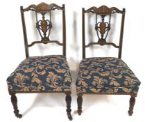 A pair of Edwardian mahogany salon chairs with urn splat backs inlaid with anthemion