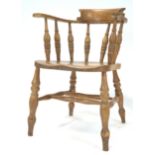 An early 20th century beech wood smokers bow arm chair, of traditional form,