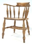 An early 20th century beech wood smokers bow arm chair, of traditional form,