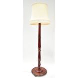 A mahogany turned standard lamp, on round stained pine base, on bun feet,