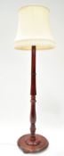 A mahogany turned standard lamp, on round stained pine base, on bun feet,