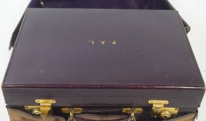 A ladies purple leather travelling dressing case (devoid of contents),