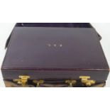A ladies purple leather travelling dressing case (devoid of contents),