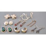 A collection of eight pairs of pierced and clip silver earrings of variable designs.