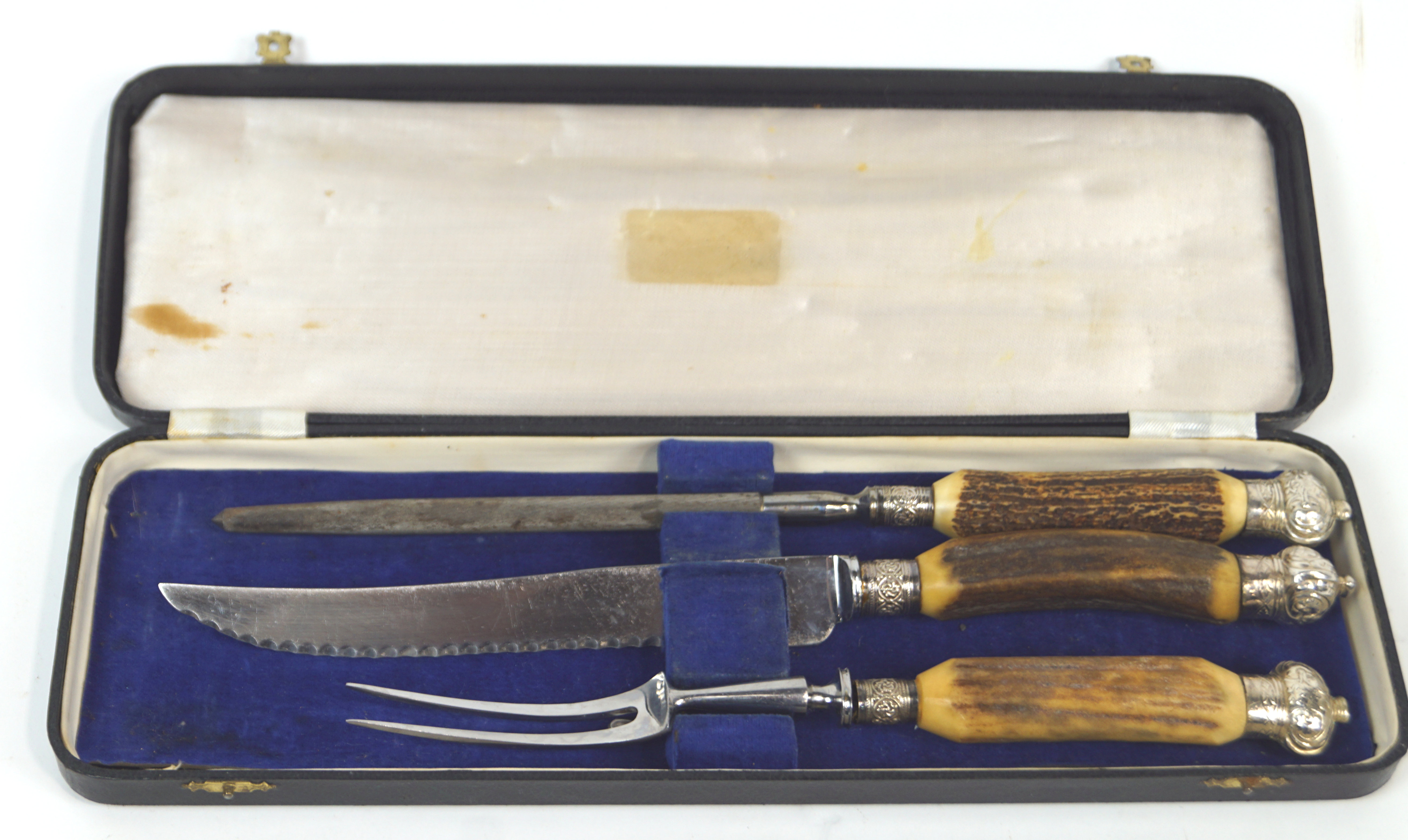 A cased three piece carving set, comprising : knife with serrated blade,