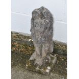 A reconstituted stone lion, sitting proud on a square base,