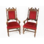 A pair of Victorian oak armchairs, with broken swan neck pediment, above a lozenge carved frieze,