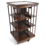 An Edwardian mahogany revolving bookcase with boxwood stringing, the x base on casters,