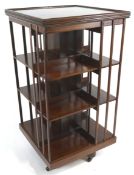 An Edwardian mahogany revolving bookcase with boxwood stringing, the x base on casters,