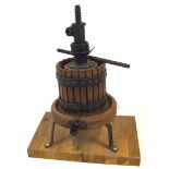 A miniature cider press, of traditional form, in light wood and iron, mounted on a board,