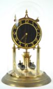 A German (Kieninger und Obergfell) 400 day torsion clock, in gilt finish with a black Arabic dial,