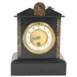 A black slate clock with double pediment top and marble accents over a round cream Arabic dial,