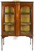 An Edwardian mahogany display cabinet with two glazed doors flanking a marquetry panel