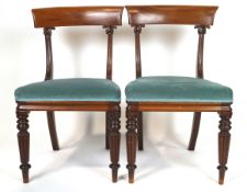 Two William IV mahogany dining chairs, with shaped bar backs and foliate carved uprights,