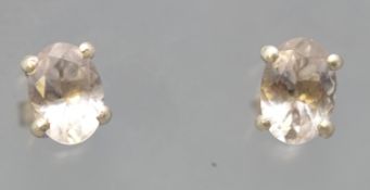 A pair of white metal single stone stud earrings. Each set with an oval faceted cut pale morganite.