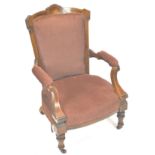 A Victorian walnut and marquetry framed armchair with upholstered back,