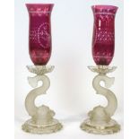 A pair of Baccarat dolphin candlesticks, each with engraved ruby-tinted engraved flared shades,