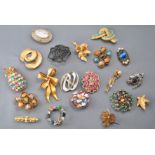 A collection of twenty costume brooches of variable designs.