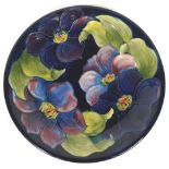 A William Moorcroft plate, in the 'Clematis' pattern, impressed factory marks,