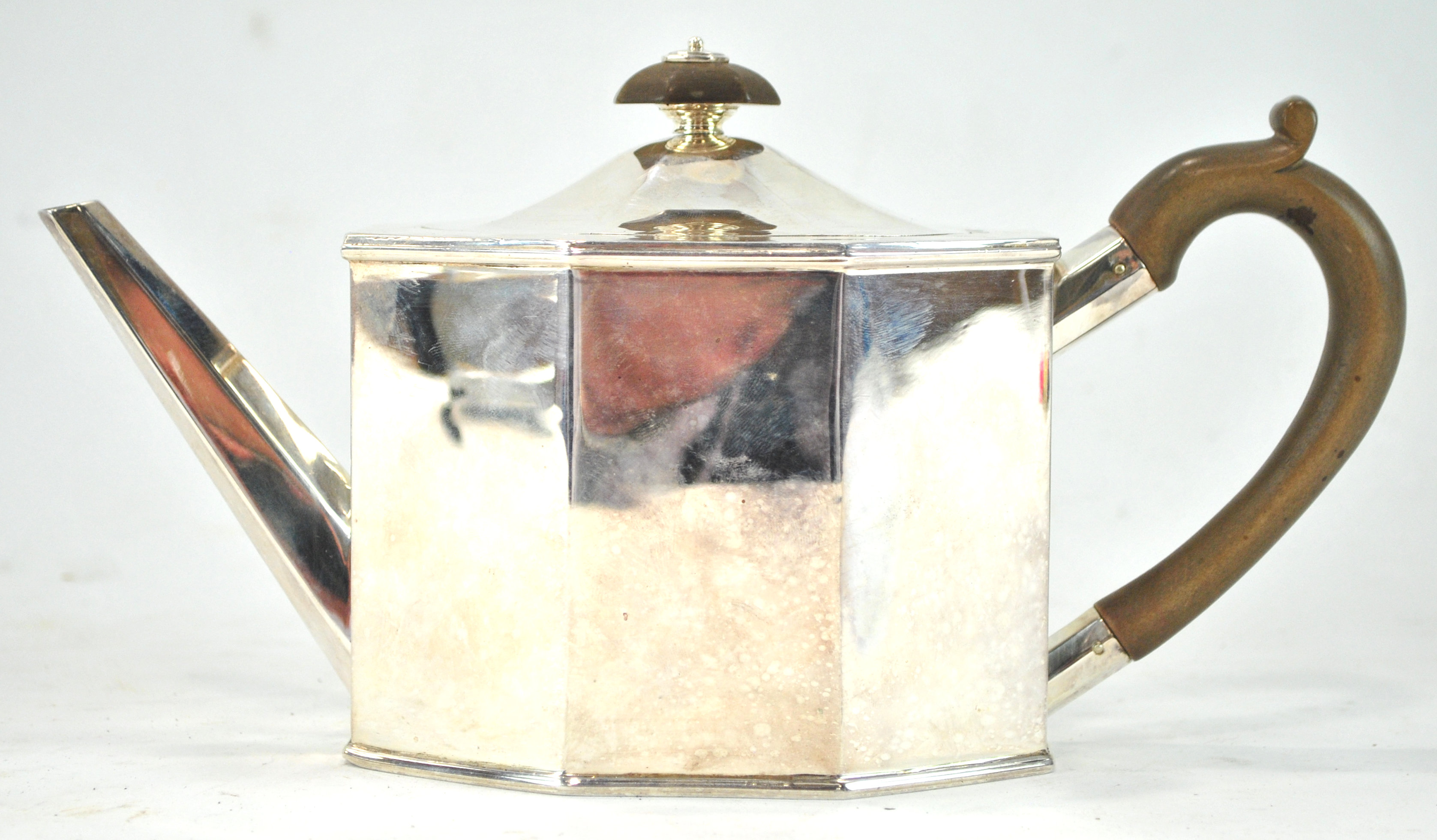 A silver teapot of flat panel octagonal form and domed cover,