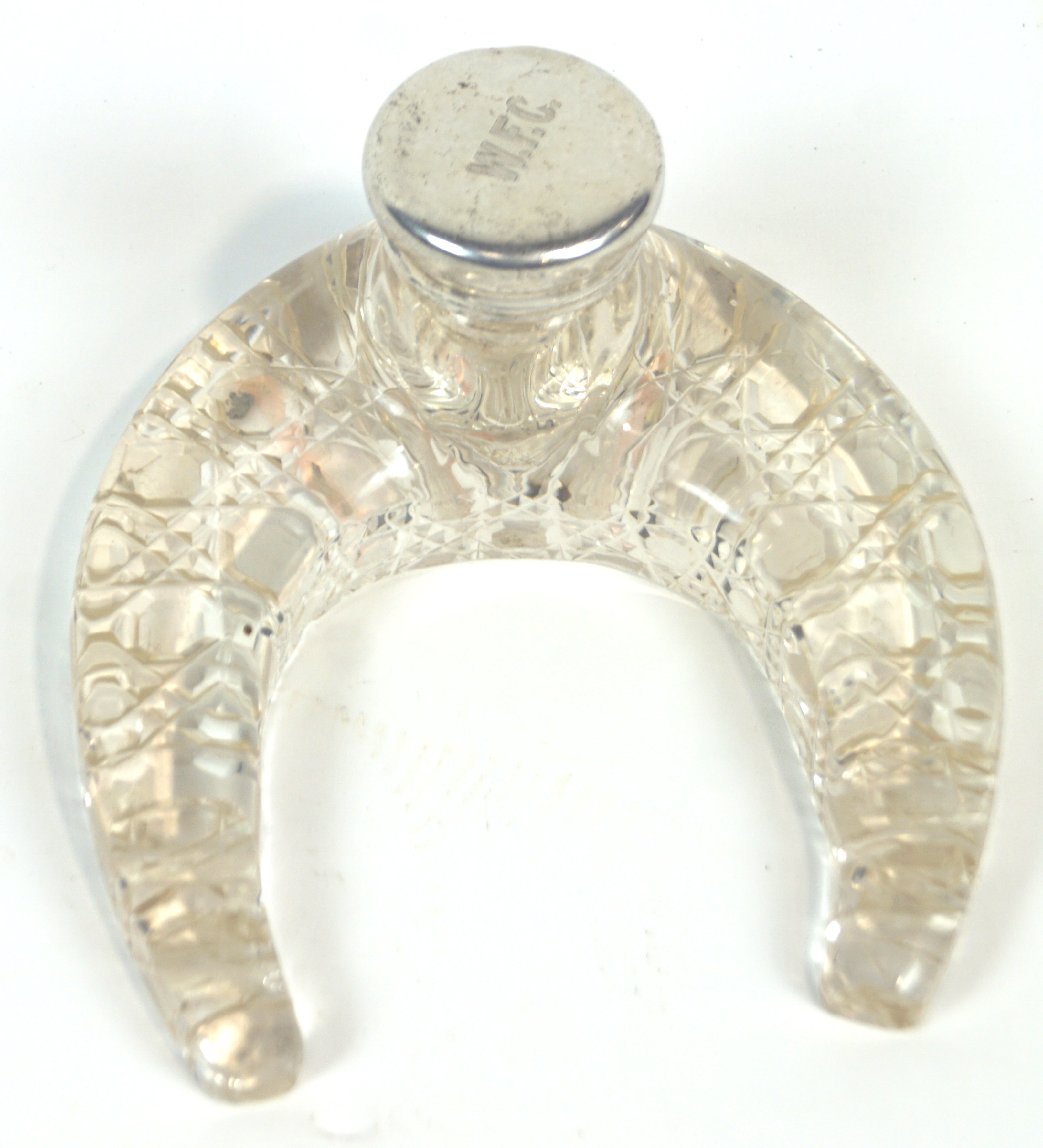 A cut glass and silver ink stand, the glass base shaped like a life size horseshoe,