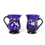 A 19th century blue glass mug painted in enamels and gilt, with loop handle and pontil mark,